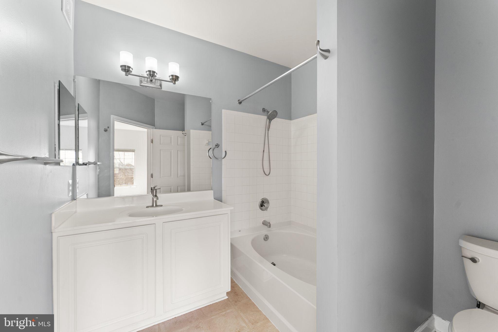 42427 Goldenseal Square Brambleton, VA 20148 - Photo 37 of 52 a bathroom with a tub sink double vanity and mirror