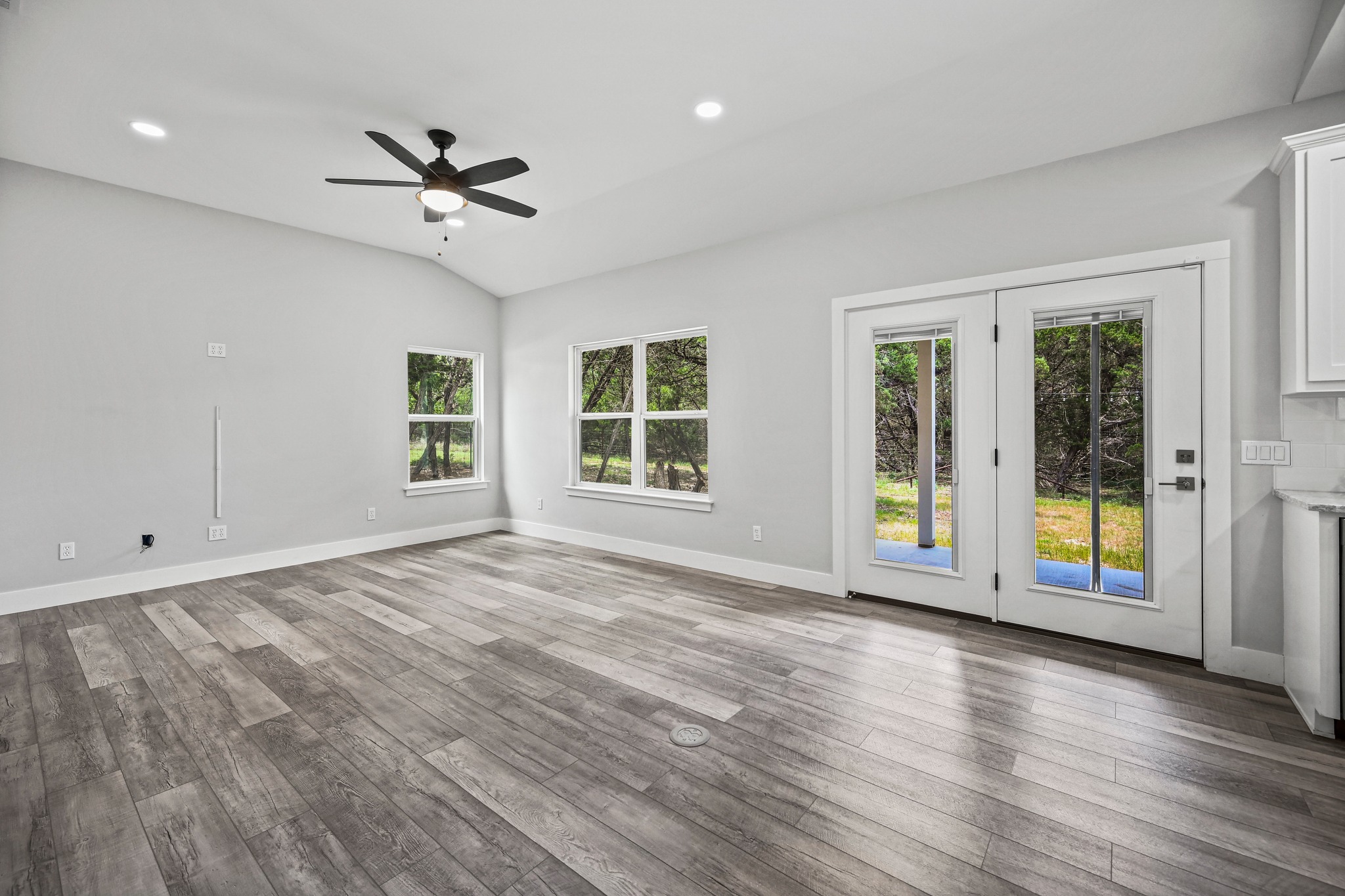 231 North Rainbow Ranch Road Wimberley, TX 78676 - Photo 10 of 40 Natural light floods this living area through ample windows and a glass-paned door.