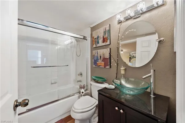 a bathroom with a granite countertop sink mirror toilet and bathtub