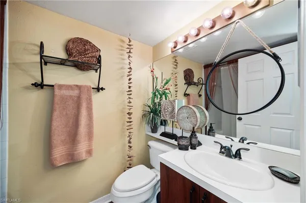 a bathroom with a sink vanity mirror and toilet