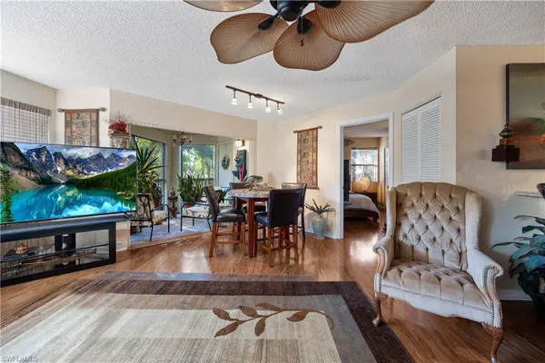 a living room with furniture a dining table and chairs with wooden floor