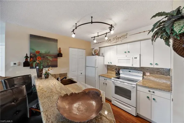 a kitchen with sink refrigerator and cabinets