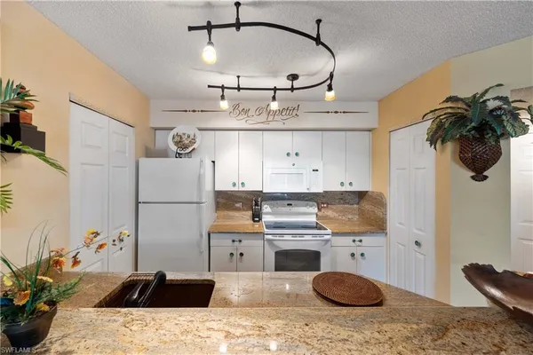 a kitchen with a sink a refrigerator and cabinets