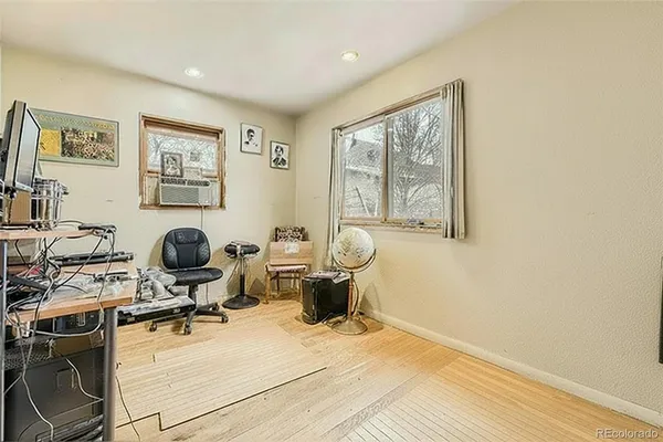 a view of a workspace with wooden floor and a window