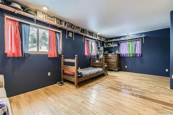 a bedroom with a bed and large windows