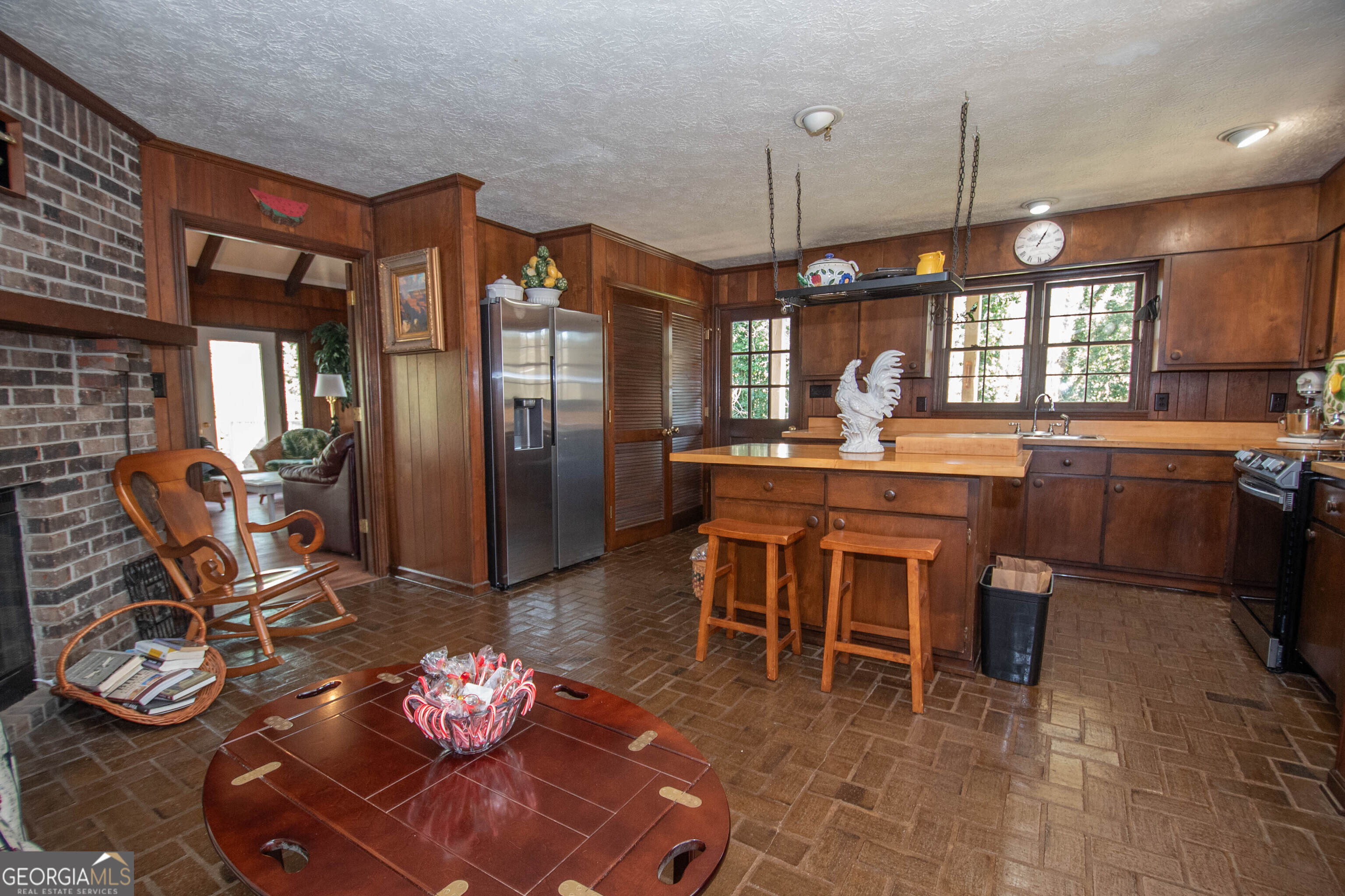 151 Evans Road Milner, GA 30257 - Photo 43 of 53 a kitchen with stainless steel appliances granite countertop a stove a refrigerator a sink a dining table and chairs with wooden floor