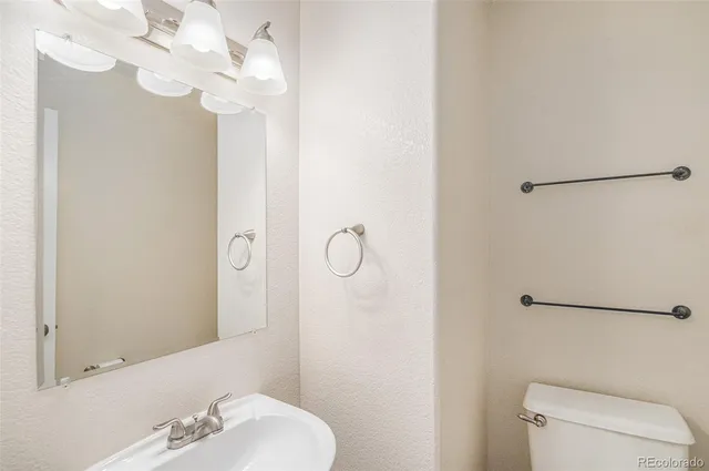 a bathroom with a sink a toilet and a mirror