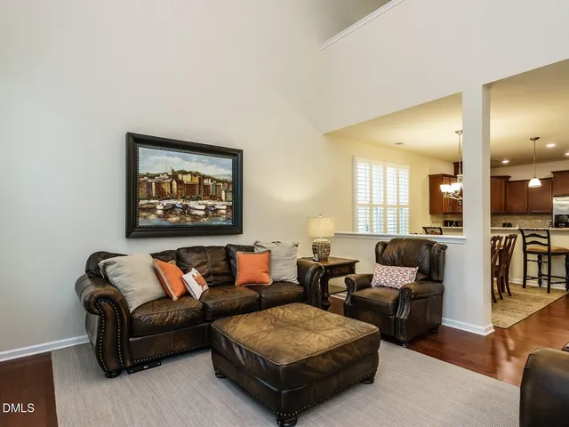 a view of an empty room with wooden floor fireplace and a window