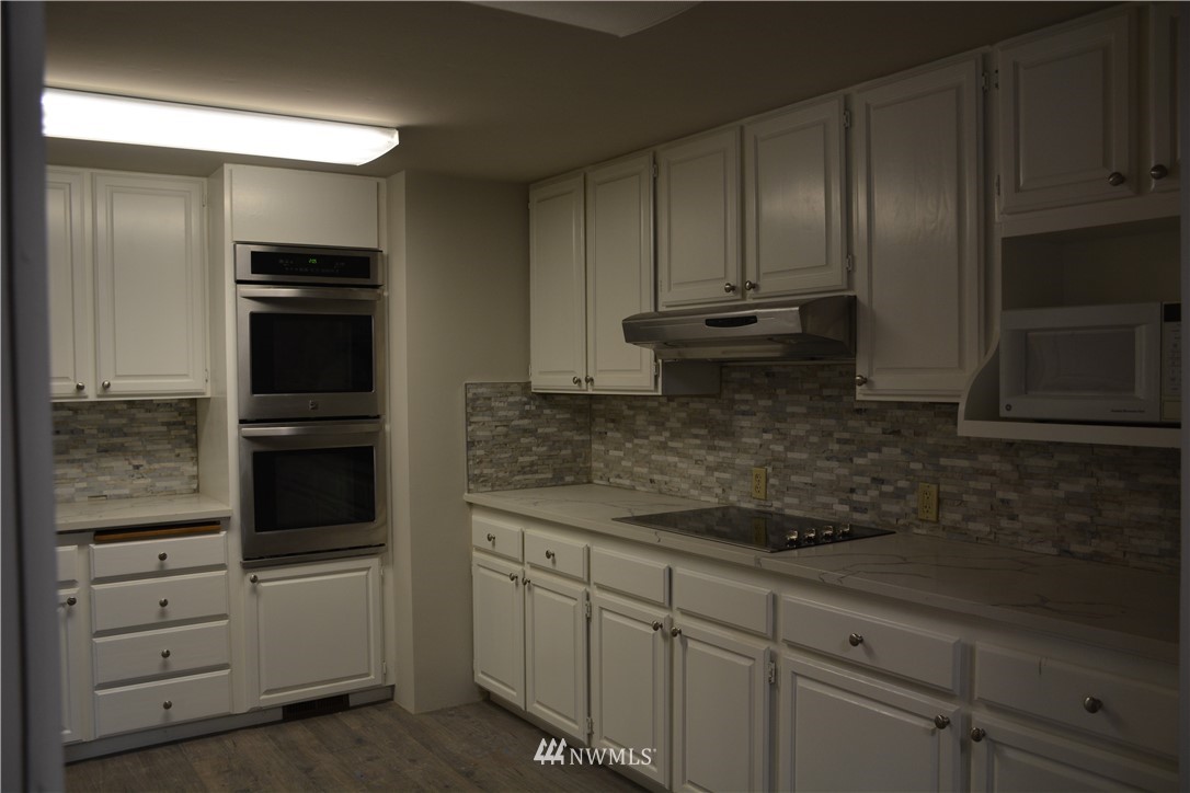 12606 Chain Lake Road Snohomish, WA 98290 - Photo 12 of 25 a kitchen with white cabinets and appliances