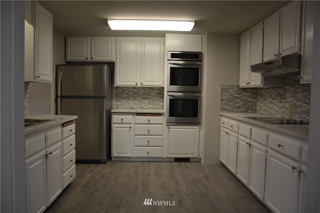 12606 Chain Lake Road Snohomish, WA 98290 - Photo 13 of 25 a kitchen with white cabinets and stainless steel appliances