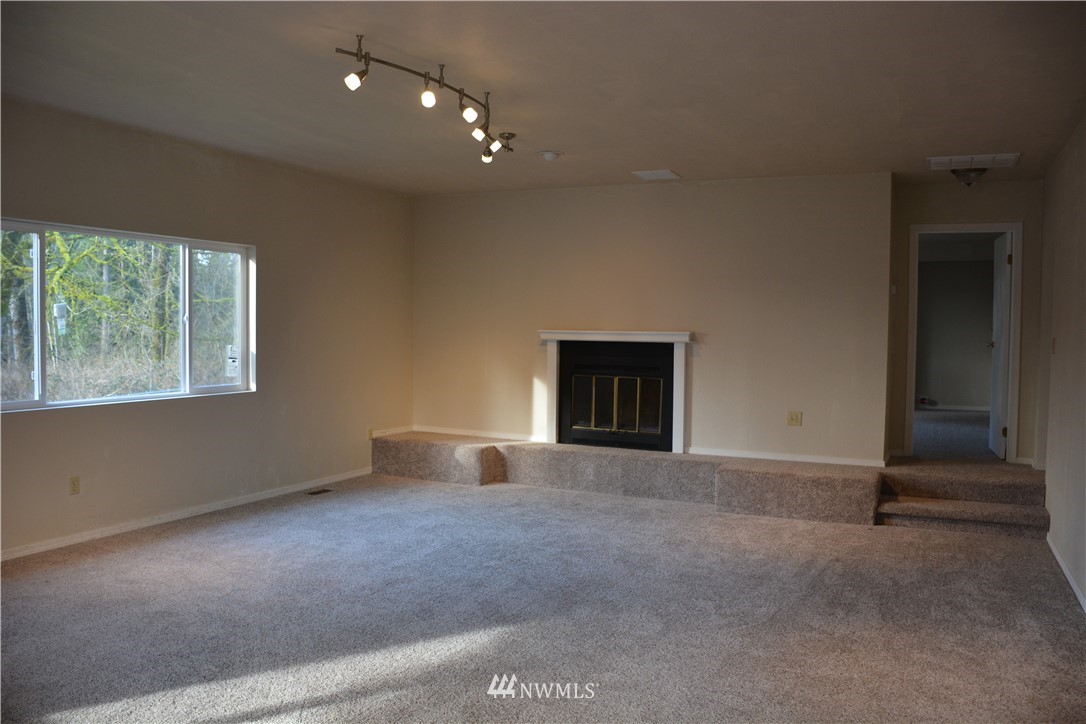 12606 Chain Lake Road Snohomish, WA 98290 - Photo 7 of 25 an empty room with windows and fireplace