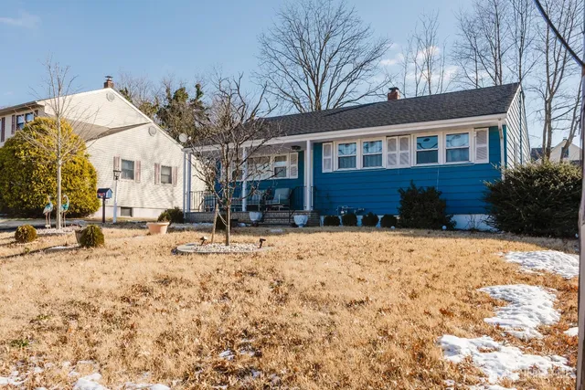 a front view of a house with a yard covered in snow