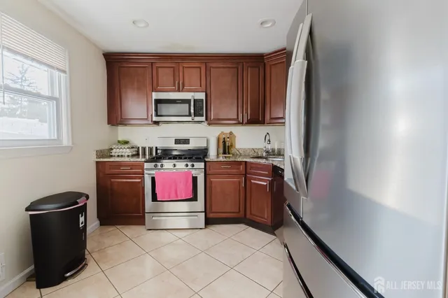 a kitchen with stainless steel appliances granite countertop a refrigerator stove and sink