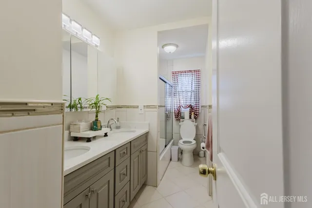 a bathroom with a sink a toilet and a mirror