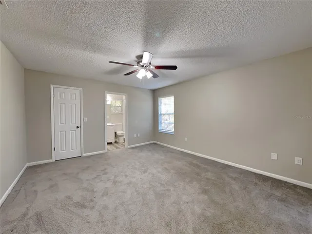 a view of an empty room with a ceiling fan