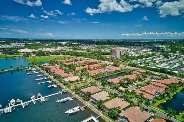 an aerial view of a tennis ground and a cars park side of the lake