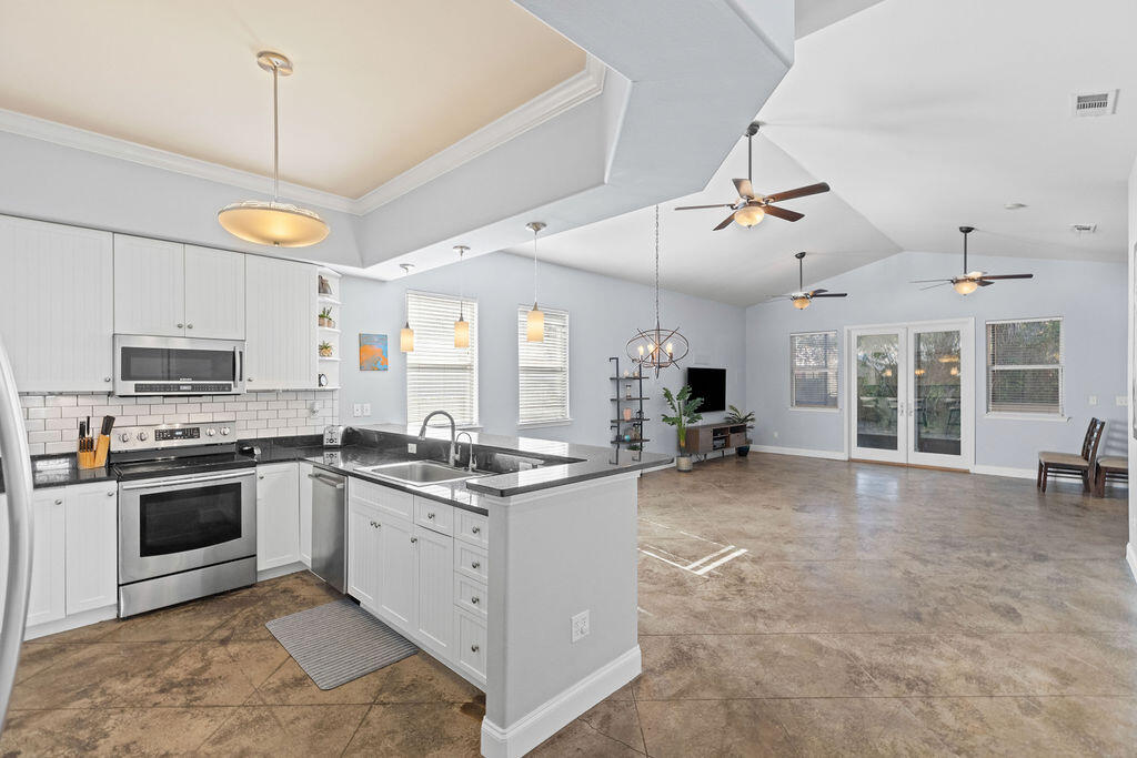 323 Main Street Destin, FL 32541 - Photo 23 of 43 a kitchen with stainless steel appliances granite countertop a stove and cabinets