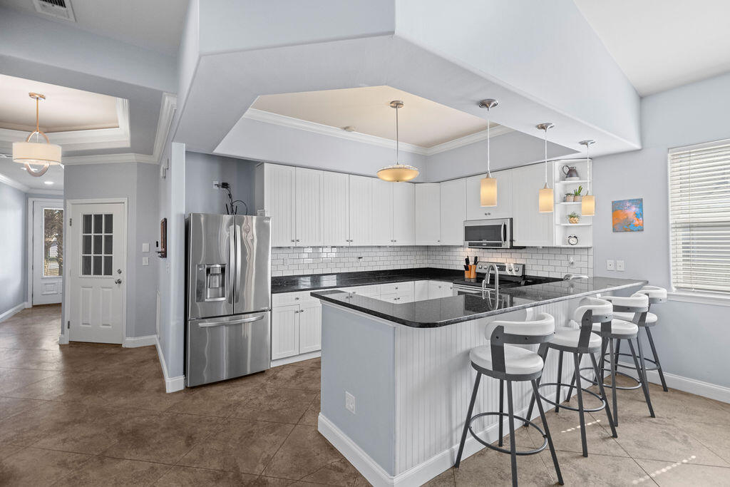 323 Main Street Destin, FL 32541 - Photo 24 of 43 a kitchen with a sink a refrigerator and chairs
