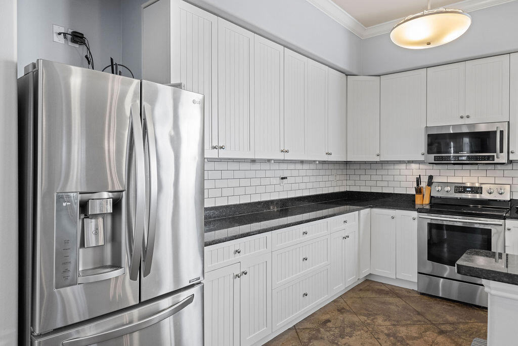 323 Main Street Destin, FL 32541 - Photo 26 of 43 a kitchen with granite countertop white cabinets and stainless steel appliances