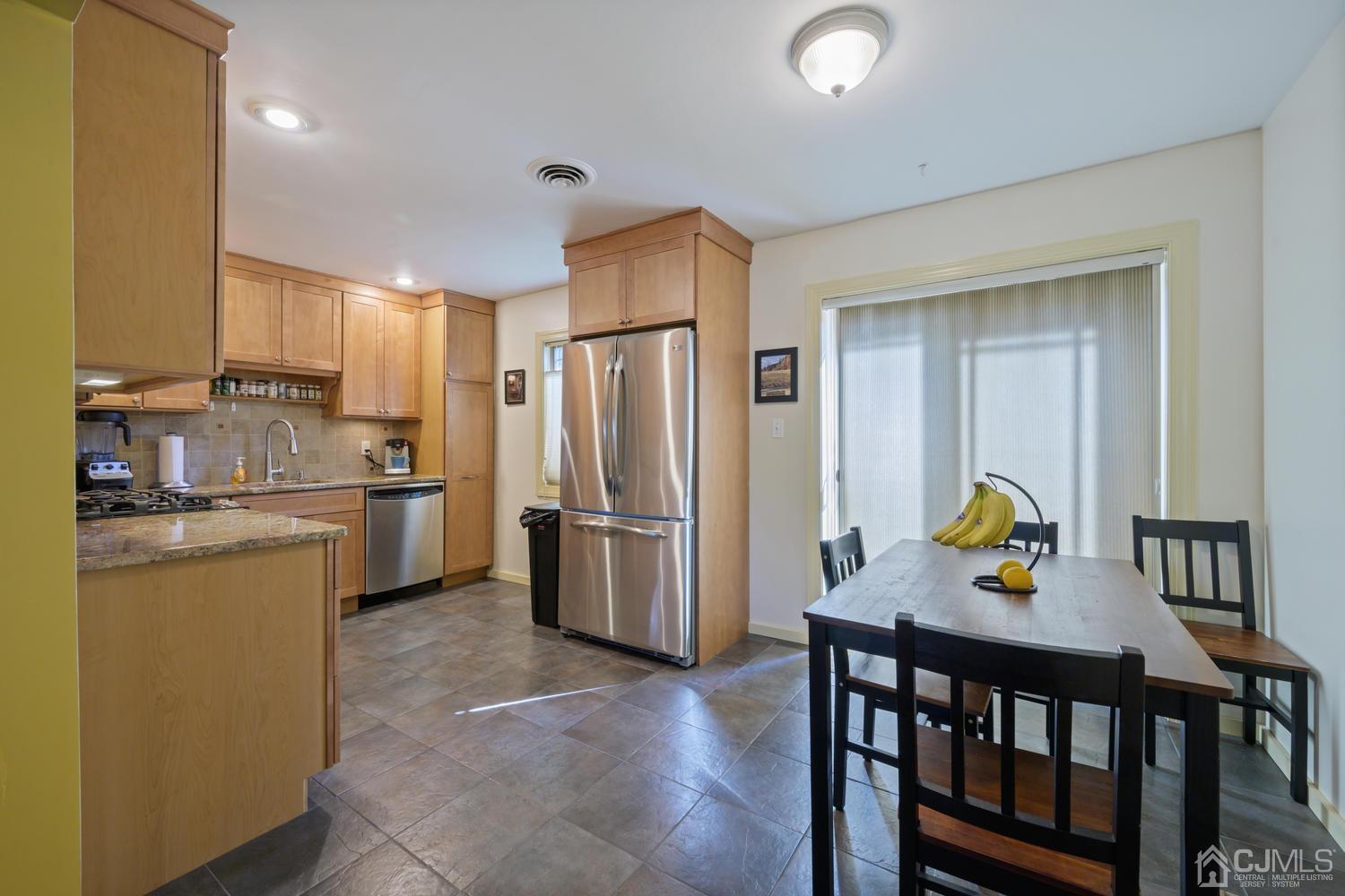 49 George Avenue Middlesex, NJ 08846 - Photo 11 of 20 a kitchen with stainless steel appliances a dining table chairs and refrigerator
