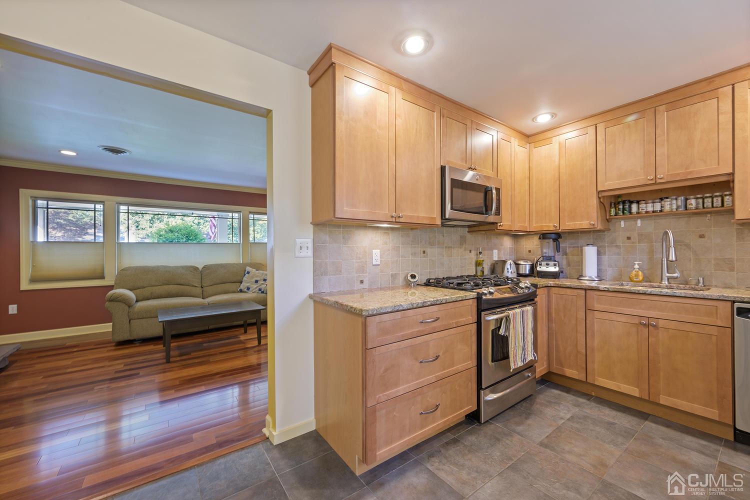 49 George Avenue Middlesex, NJ 08846 - Photo 7 of 20 a kitchen with kitchen island granite countertop a stove top oven sink and cabinets