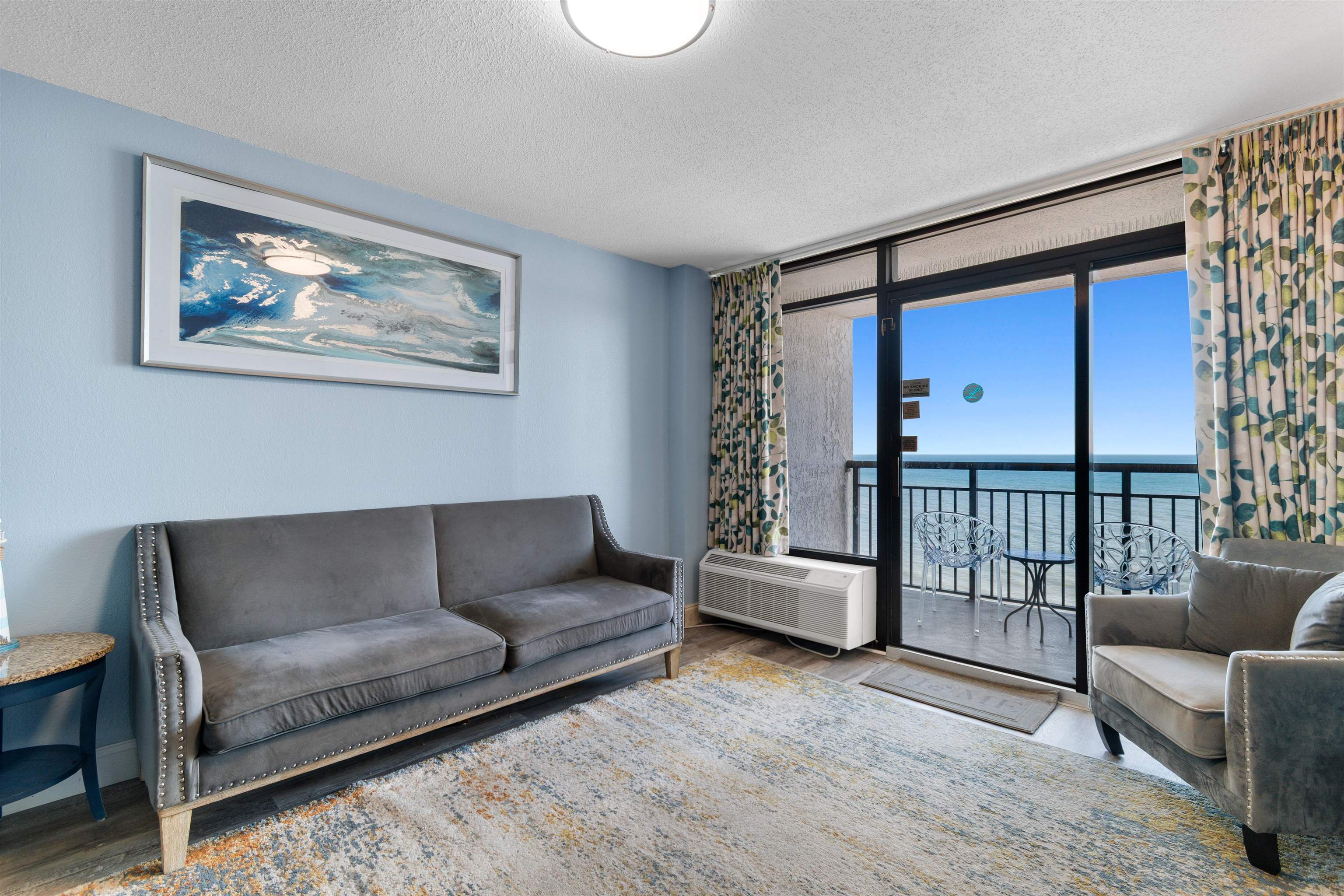 1501 South Ocean Boulevard, Unit 1237 Myrtle Beach, SC 29577 - Photo 20 of 40 Living area with a water view, a textured ceiling, wood finished floors, floor to ceiling windows, and a wall mounted air conditioner