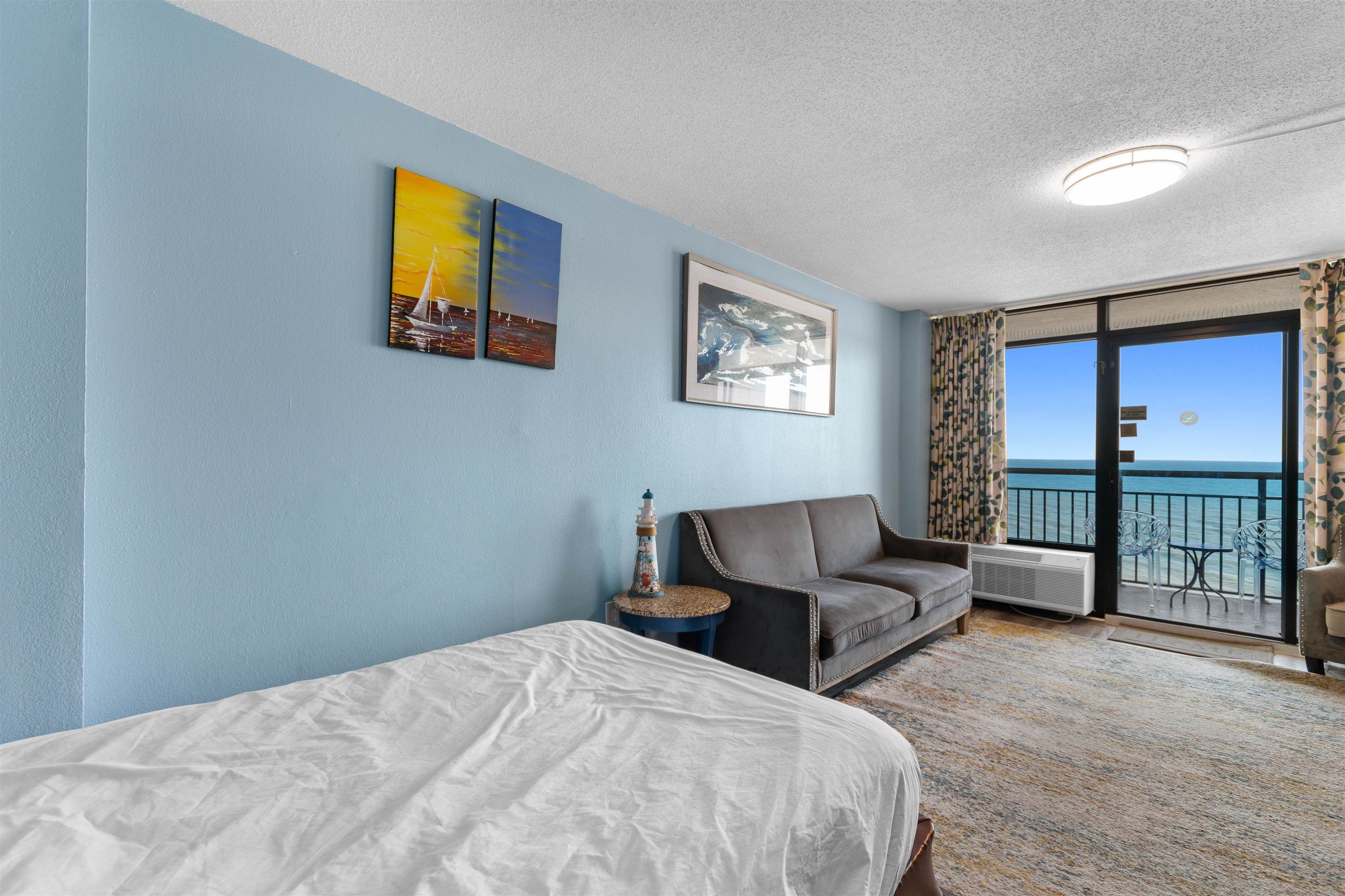 1501 South Ocean Boulevard, Unit 1237 Myrtle Beach, SC 29577 - Photo 24 of 40 Bedroom with a textured ceiling, a water view, a wall of windows, and access to exterior