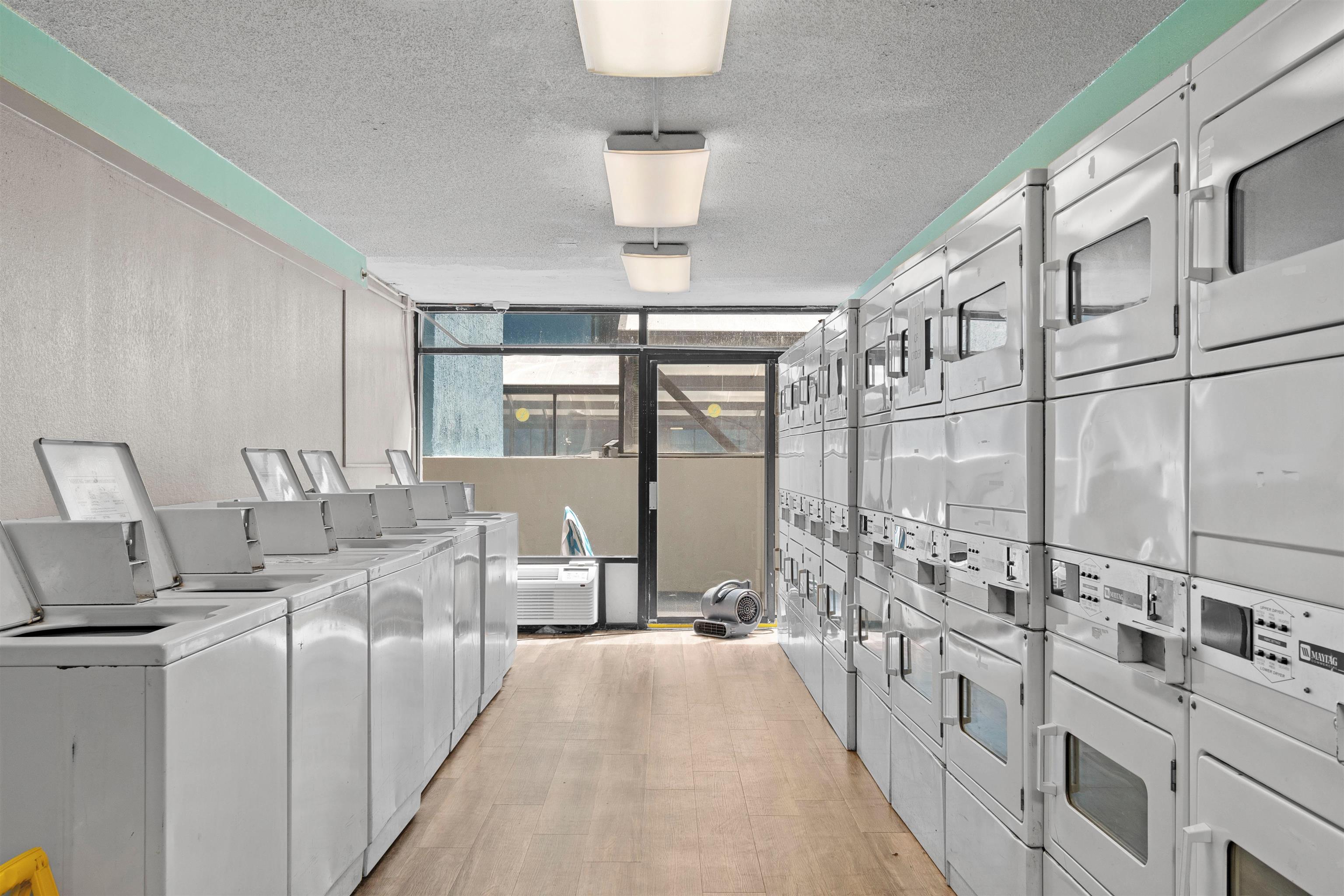1501 South Ocean Boulevard, Unit 1237 Myrtle Beach, SC 29577 - Photo 39 of 40 Community laundry room with a textured ceiling, expansive windows, and a wall mounted air conditioner