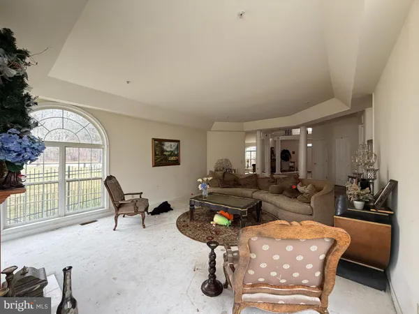 a living room with furniture fireplace and large windows