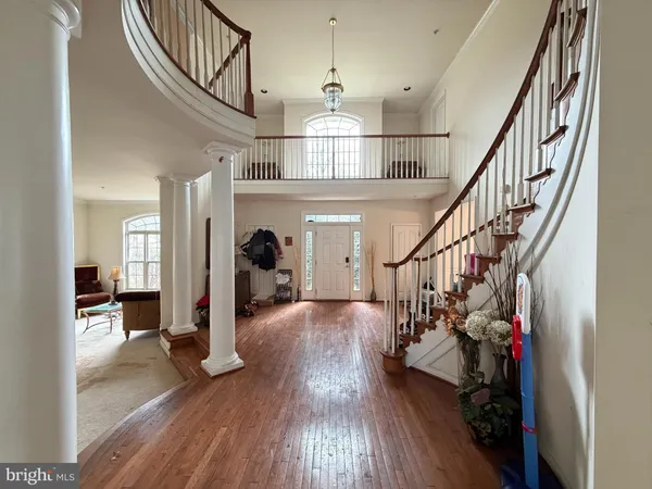 a view of a hallway with wooden floor stairs and a livingroom with wooden floor
