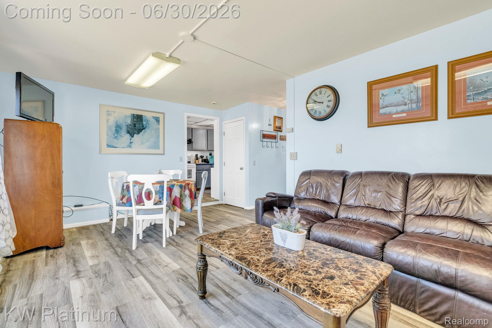 2235 South Lake Shore Road Harbor Beach, MI 48441 - Photo 61 of 99 Open living area featuring wood-finish flooring, light blue walls, and a white ceiling with a fluorescent light fixture