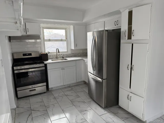 a kitchen with stainless steel appliances a refrigerator sink and cabinets