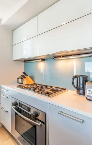 a kitchen with kitchen island a sink stove and cabinets
