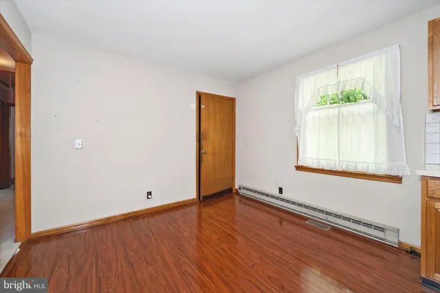 an empty room with windows and fireplace