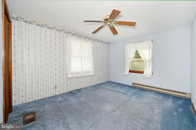 a living room with furniture a flat screen tv and a floor to ceiling window