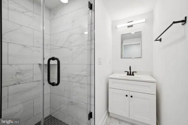 a bathroom with a shower sink and mirror