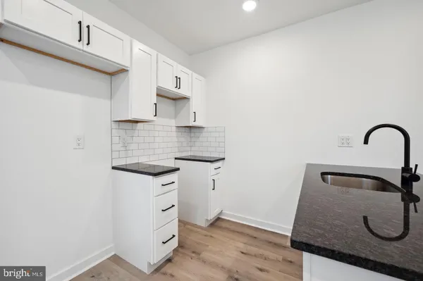 a kitchen with granite countertop a sink and a stove