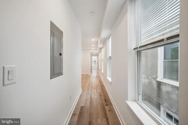 a view of a hallway with wooden floor and staircase