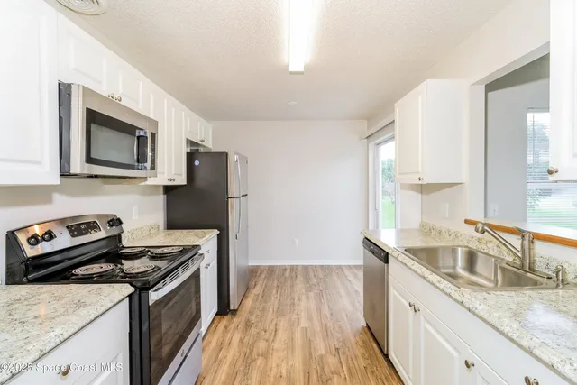 a kitchen with a sink stove and microwave