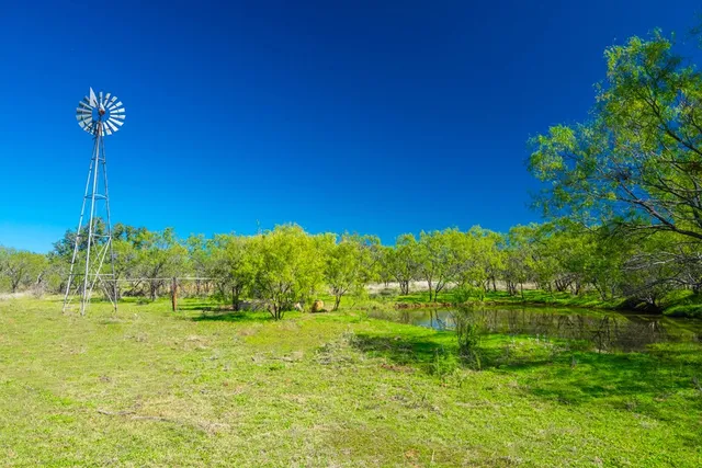 a view of backyard with swimming pool and seating space