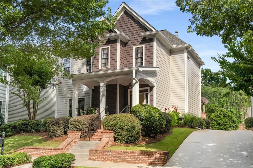 a front view of a house with a yard and potted plants