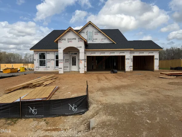 a view of a white house with a large space in front of it