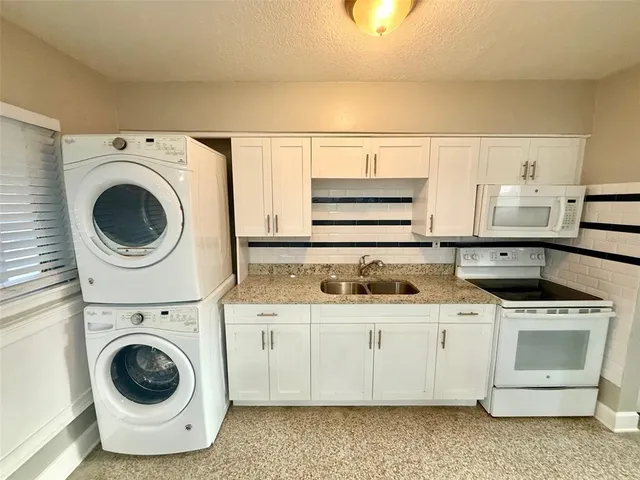 a utility room with sink dryer and washer