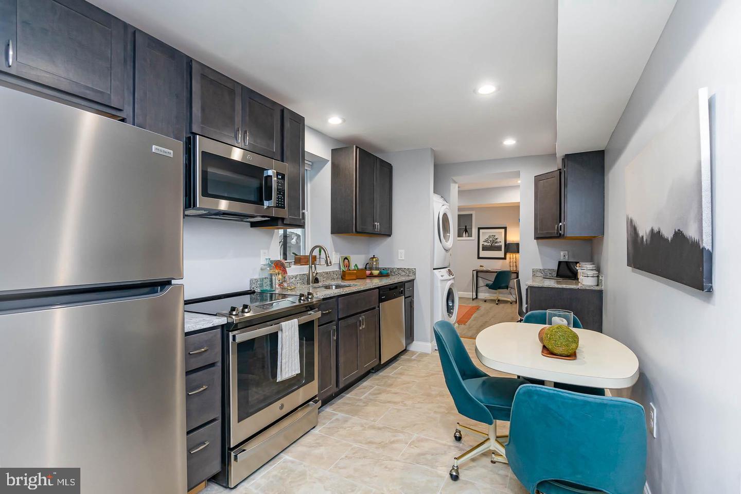 1709 Bank Street Baltimore, MD 21231 - Photo 14 of 49 a kitchen with stainless steel appliances a stove a refrigerator a sink a stove a dining table and chairs