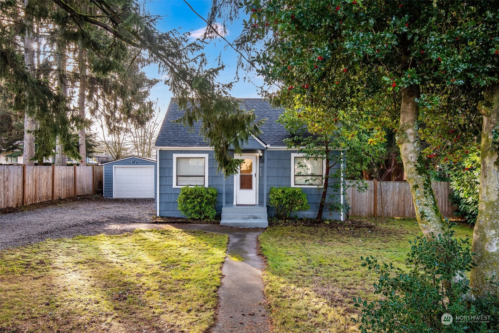 a front view of a house with a yard and tree
