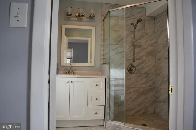 a bathroom with a shower sink and mirror