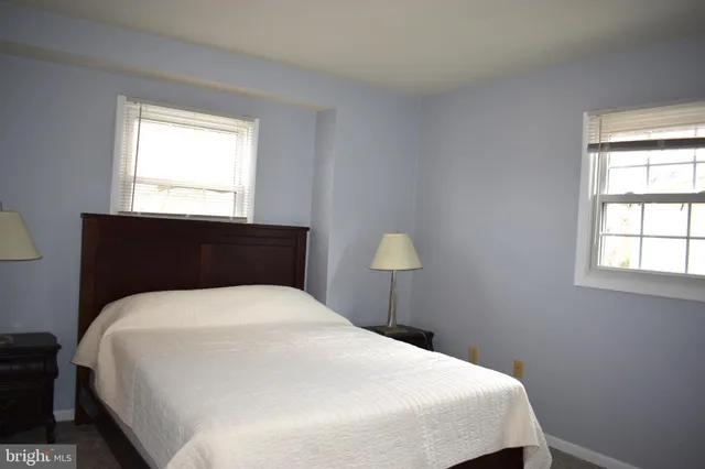 a bedroom with a bed and a lamp on dresser