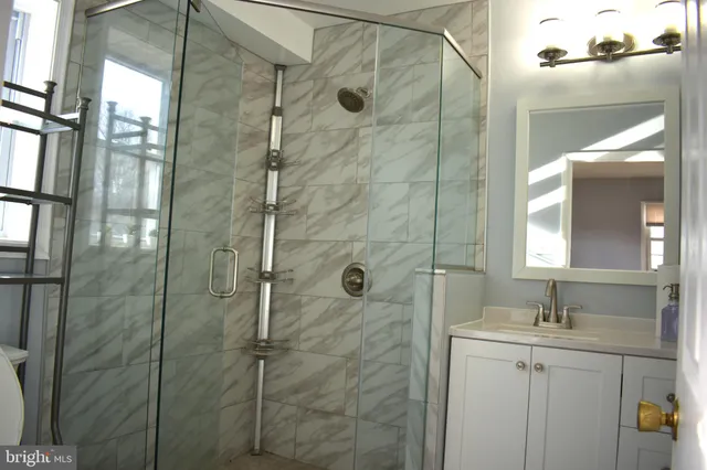 a bathroom with a shower sink and mirror