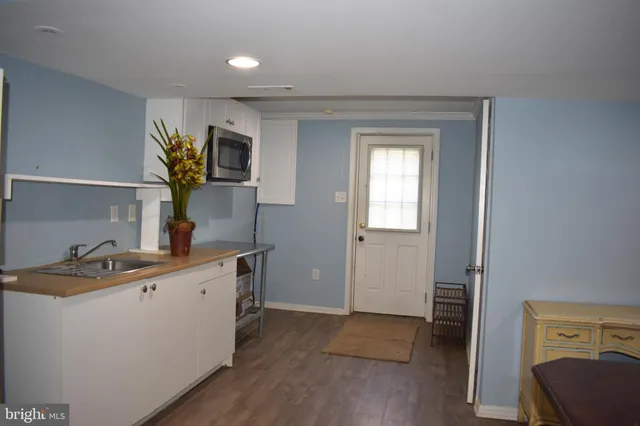 a kitchen with a sink cabinets and wooden floor