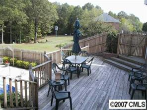 2704 Farmlake Lane Fort Mill, SC 29708 - Photo 6 of 8 a view of a patio with table and chairs with wooden floor and fence